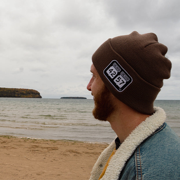 man wearing 42-57 beanie on the beach