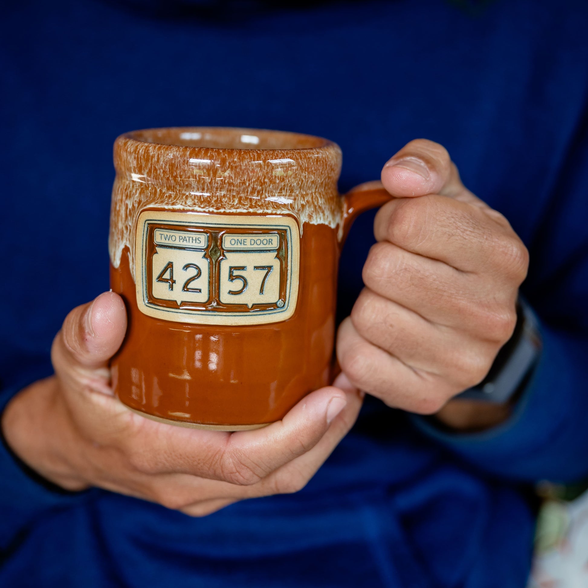 Person holding handcrafted 42-57 Gallery Mug in Door County, Wisconsin