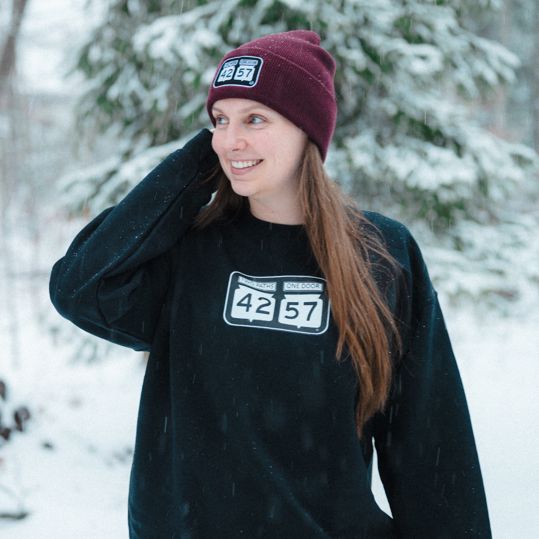Model wearing 42-57 Unisex Timeless Crewneck Sweatshirt in black during winter in Door County, Wisconsin