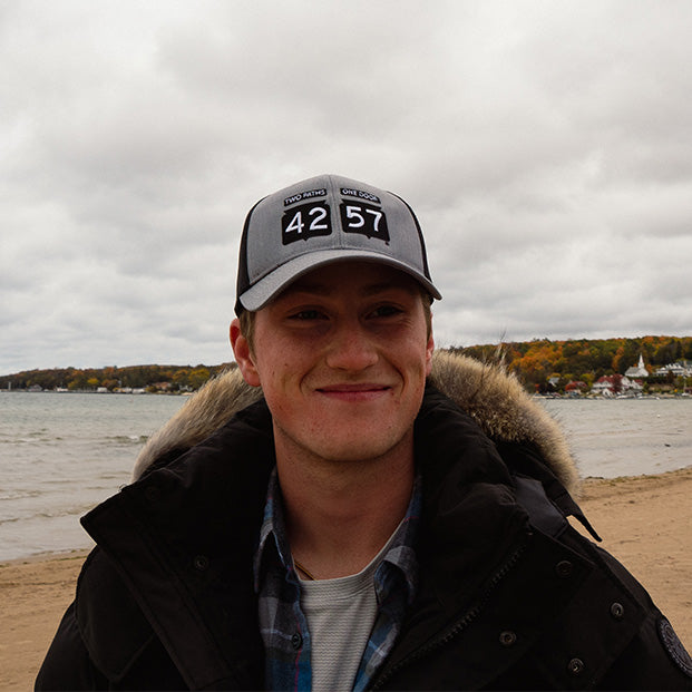 man wearing 42-57 trucker cap on the beach